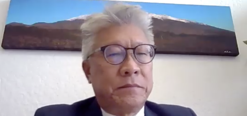 Man in suit wearing glasses on video call