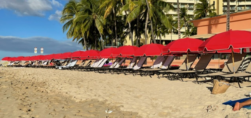 Sandy beach with red umbrellas and loungers